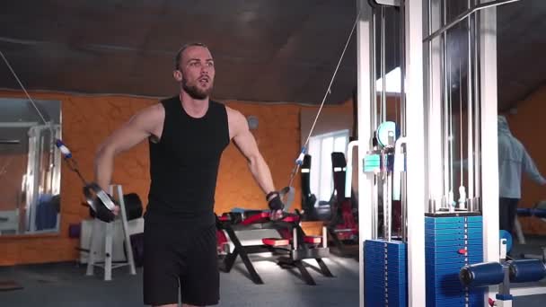 Guy kulturista v tělocvičně, pracuje s barem, které je třeba utáhnout, zlepšení triceps, velký prsní sval a přední deltový sval. Koncept milovat sporty, jít do posilovny jíst pravé štíhlé tělo být zdravý — Stock video