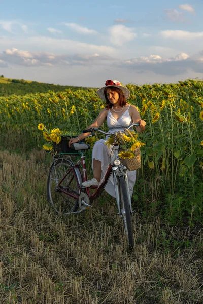 Žena Klobouku Bílých Šatech Bicyklem Prochází Pylem Slunečnicemi — Stock fotografie