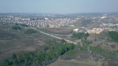 İnsansız hava aracı Avrupa 'nın tepeleri ve ormanlarıyla çevrili küçük bir köyünde uçuyor. Baharın başında. Moldova Cumhuriyeti.