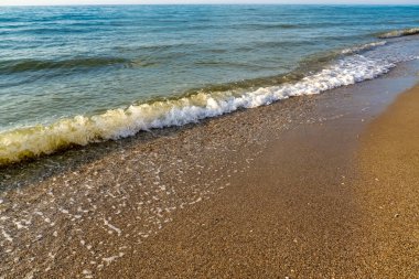Kumlu sahilde denizin yumuşak dalgası