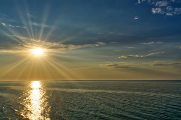 Altın Sahil Sahili sahilinde, renkli bulutlu bir gökyüzünden yükselen güneşin okyanus manzarası..