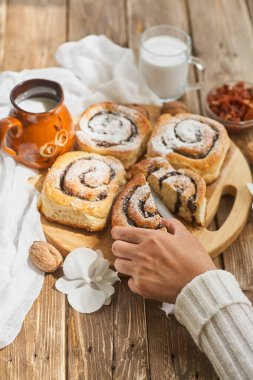 Dişi el yapımı reçelli çörekler, cevizli ve sütlü eski ahşap masada servis ediliyor.