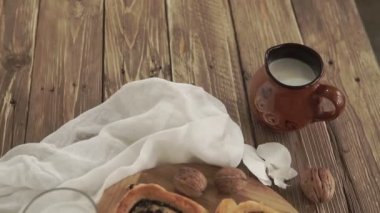 Reçelli ev yapımı çörekler, cevizli ve sütlü eski ahşap masada servis ediliyor.