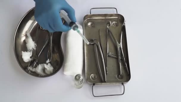 医師の注射器は 医療テーブルの背景に手を取ります 医療用手袋の医者の手 — ストック動画