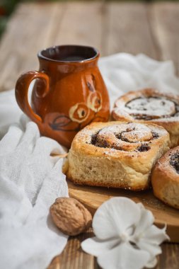 Reçelli ev yapımı çörekler, cevizli ve sütlü eski ahşap masada servis ediliyor.