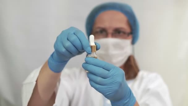 疫苗病毒 验尸官的概念 医生在模糊的蓝色背景下 手里拿着一个带有疫苗特写的安培尔 病毒防护 感冒和流感 — 图库视频影像