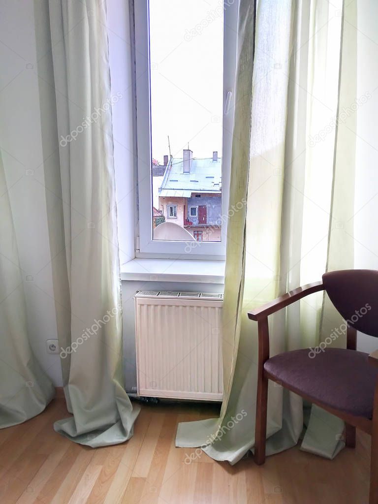 Interior of the room with a chair by the window and a view