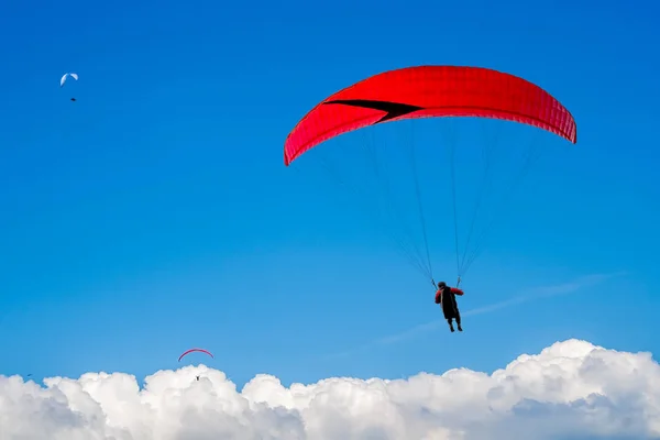 The paraglider hovers in the sky high above the clouds — Stock Photo, Image