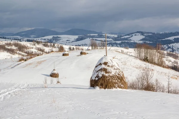 Paesaggio rurale invernale, pagliaio e neve — Foto Stock