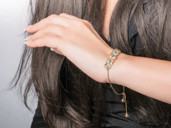 Pulsera de oro en una mano con manicura francesa, pulsera con flor, cadena ajustable —  Fotos de Stock