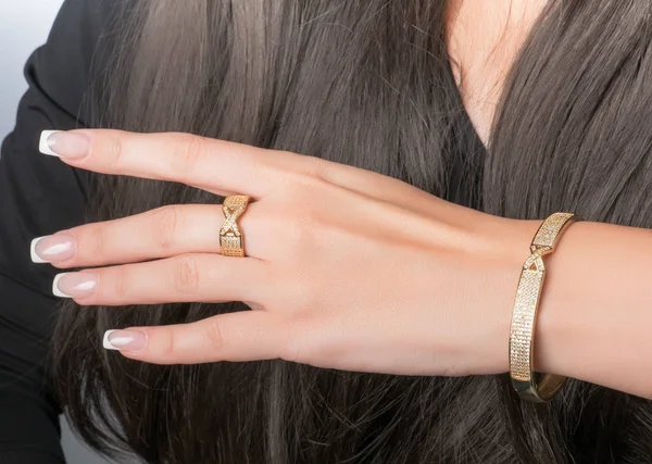 Gold ring and bracelet set on a hand with French manicure — Stock Photo, Image