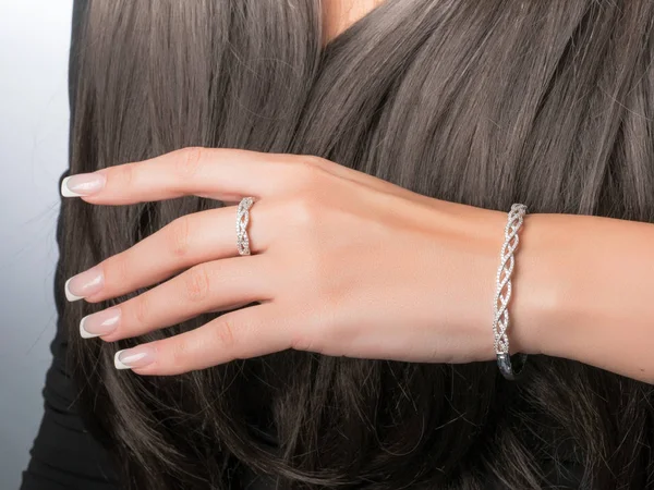 White gold ring and bracelet set on a hand with French manicure — Stock Photo, Image