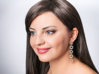 Küpe, takı ile büyük mavi gözlü kadın yüzü. Kristalleri ile damla küpe 