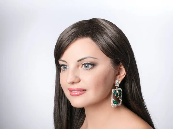 Hermosa chica con cabello castaño con pendientes de gota, piedra de gema azul, joyas — Foto de Stock