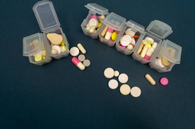 Plastik tabletler için düzenleyici. Tabletler kırmızı, beyaz, koyu arkaplanda yuvarlak. yakın plan