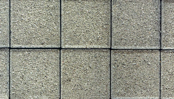 Brick pavement tile, top view. Urban texture as background. Stone pavement texture. Granite cobblestoned pavement background. closeup