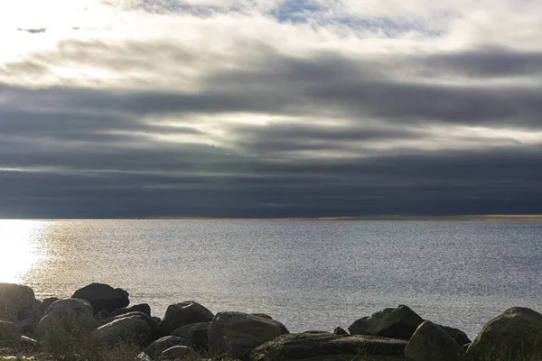 Oceaankust. stenen zee kust, bewolkte lucht in de zon — Stockfoto