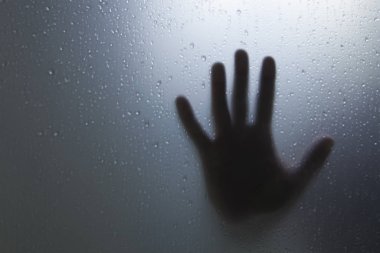 Korku konsepti, pencerenin dışındaki odaklanmış el.