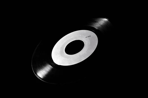 Koyu arkaplanda beyaz etiketli 45 rpm vinil disk — Stok fotoğraf