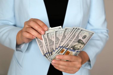 İş elbiseli bir kadın dolarları elinde tutuyor, yakın plan. Resmi, yönetici ya da işkadını parayı ofiste sayar, maaş, alışveriş, nakit