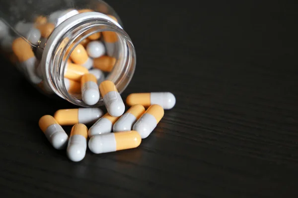 Tabletter Ett Mörkt Träbord Medicin Kapslar Utspridda Från Burk Begreppet — Stockfoto