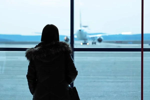 비행기를 유리창을 활주로를 바라보고 공항의 승객인 실루엣으로 보입니다 코로나 바이러스 — 스톡 사진