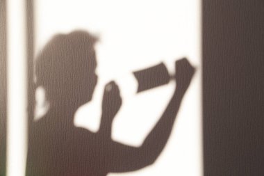 Koruyucu tıbbi maske takan bir kızın gölgesi. Covid-19 koronavirüs enfeksiyonuna karşı koruma