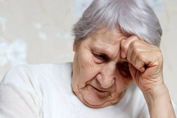 Elderly woman thought about something. Sad female with gray hair and wrinkled skin, concept of headache, memories, loneliness and old age