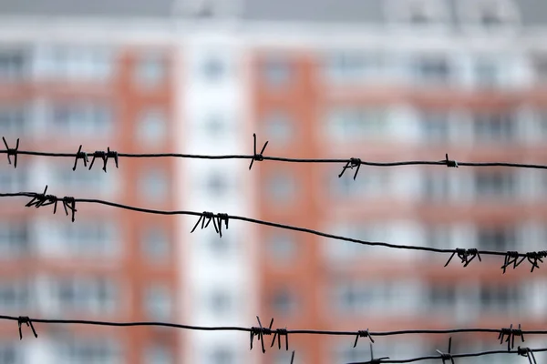 Barbed wire on residential building background. Concept of quarantine in city during quarantine at covid-19 pandemic