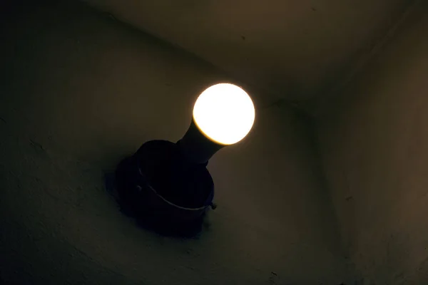 Light of an old light bulb on a wall in the dark — Stock Photo, Image