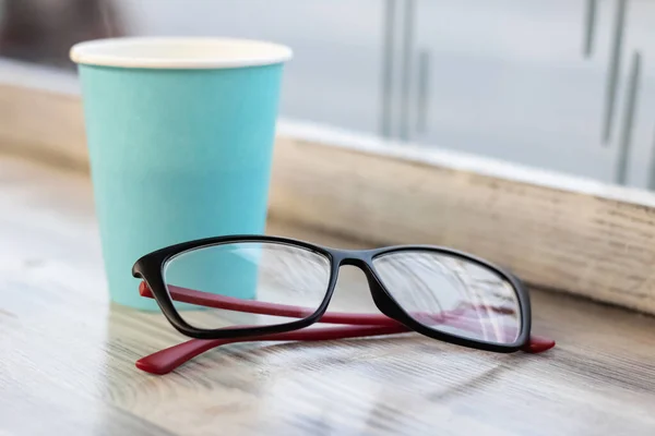 Blaue Tasse mit Kaffee und Gläsern auf Holztisch — Stockfoto