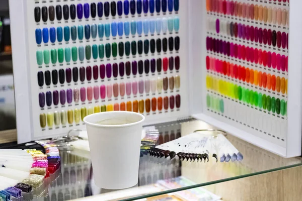 Multicolor esmalte nas unhas de plástico artificial e xícara de café — Fotografia de Stock