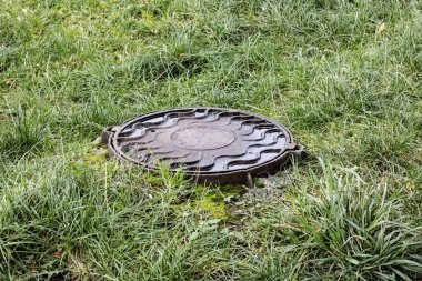 Yeşil çimlerin arasındaki lağım çukuru kapanıyor