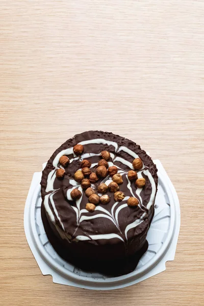 Čokoládový dort s ořechy na dřevěném stole — Stock fotografie