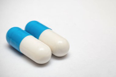 İki beyaz mavi ilaç hapı. Yakın çekim, kopyalama alanı.