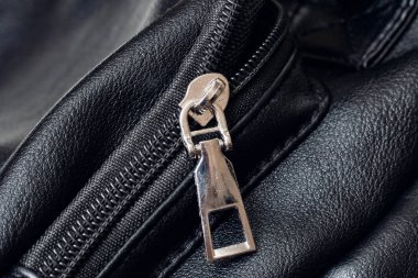 Metal clasp and zipper on leather closeup