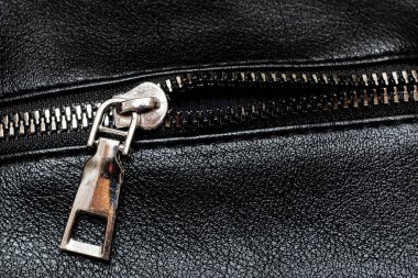 Metal clasp and zipper on leather closeup