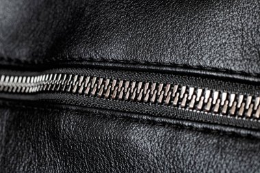 Metal clasp and zipper on leather closeup