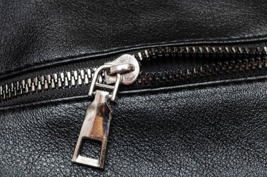 Metal clasp and zipper on leather closeup
