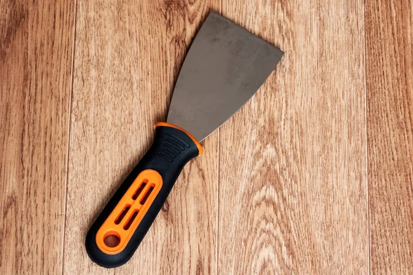 Paint spatula with black handle on wooden background — ストック写真