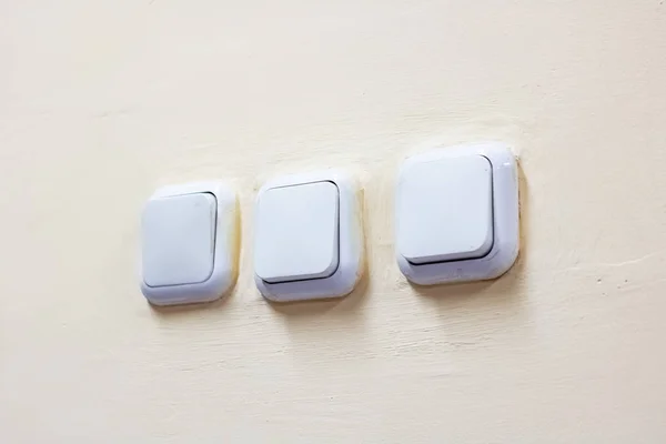 Білі електричні вимикачі на старій стіні — стокове фото