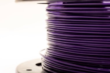 Beyaz zemin üzerinde mor kablolar olan bobin