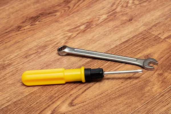 Screwdriver and wrench on a wooden table — Stock Photo, Image