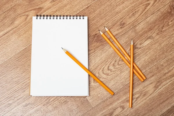 Notebook and pencils on a wooden table — Stock Photo, Image