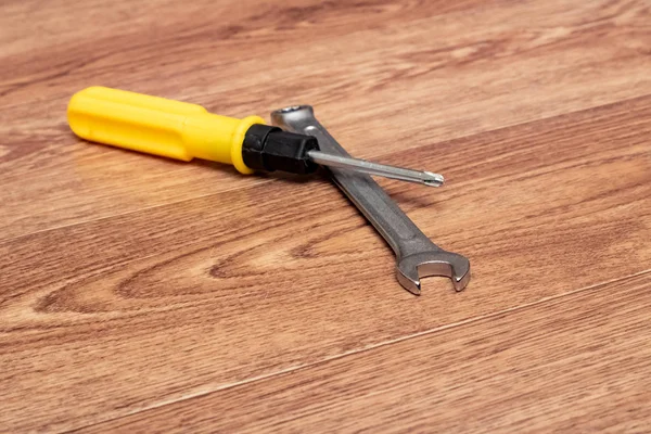 Screwdriver and wrench on a wooden table — Stock Photo, Image