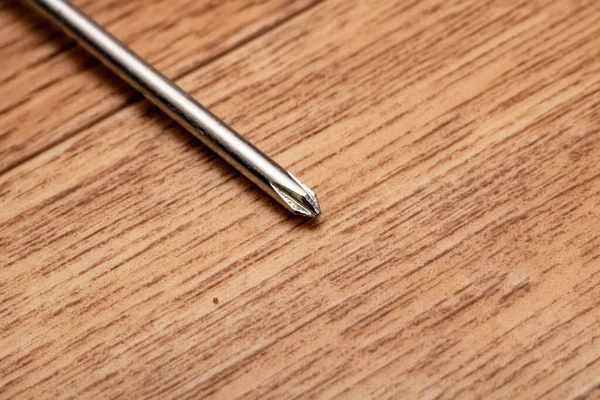Small screwdriver on wooden table close up — Stock Photo, Image