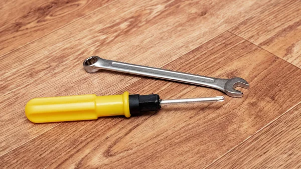 Screwdriver and wrench on a wooden table — Stock Photo, Image