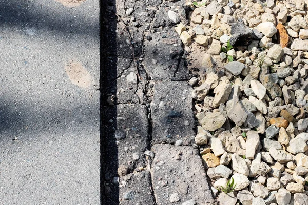 Stones and a piece of asphalt on a footpath close-up