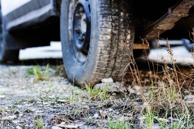 Stone under a car wheel in grass closeup