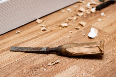 Chisel among sawdust on a wooden floor